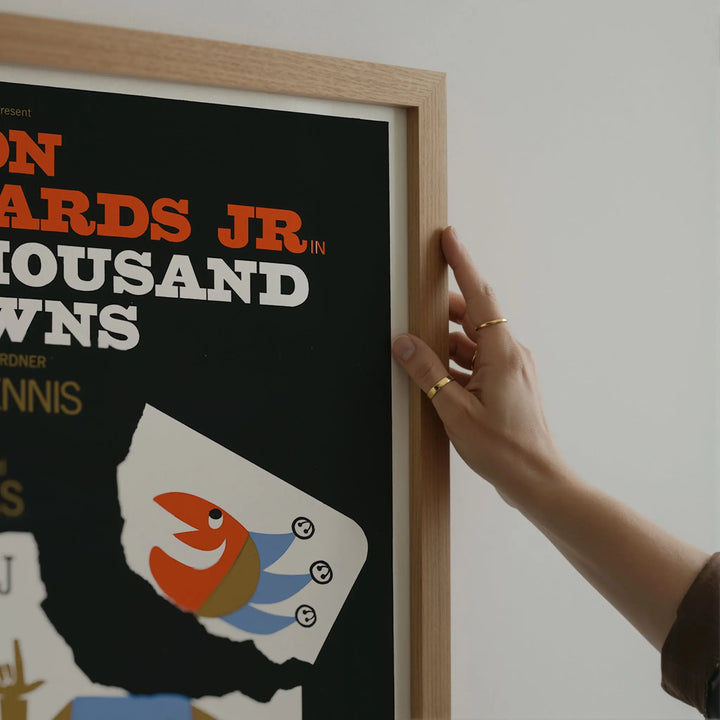 A Thousand Clowns Poster featuring vintage minimalist design with bold orange, white, and blue colors in framed art print