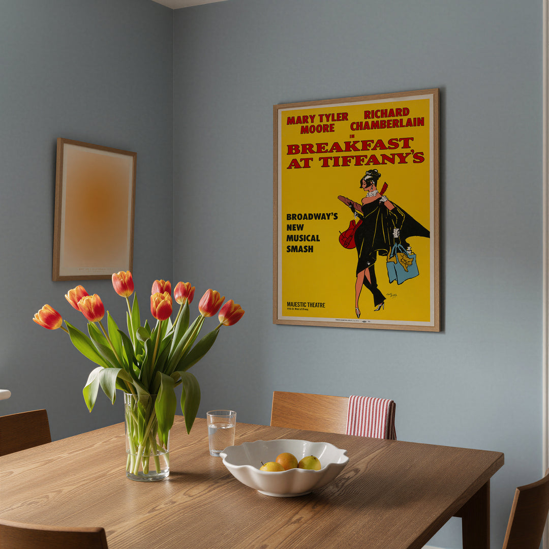 Framed Breakfast at Tiffany's Musical Poster with bright yellow background displayed in dining room wall art setting.